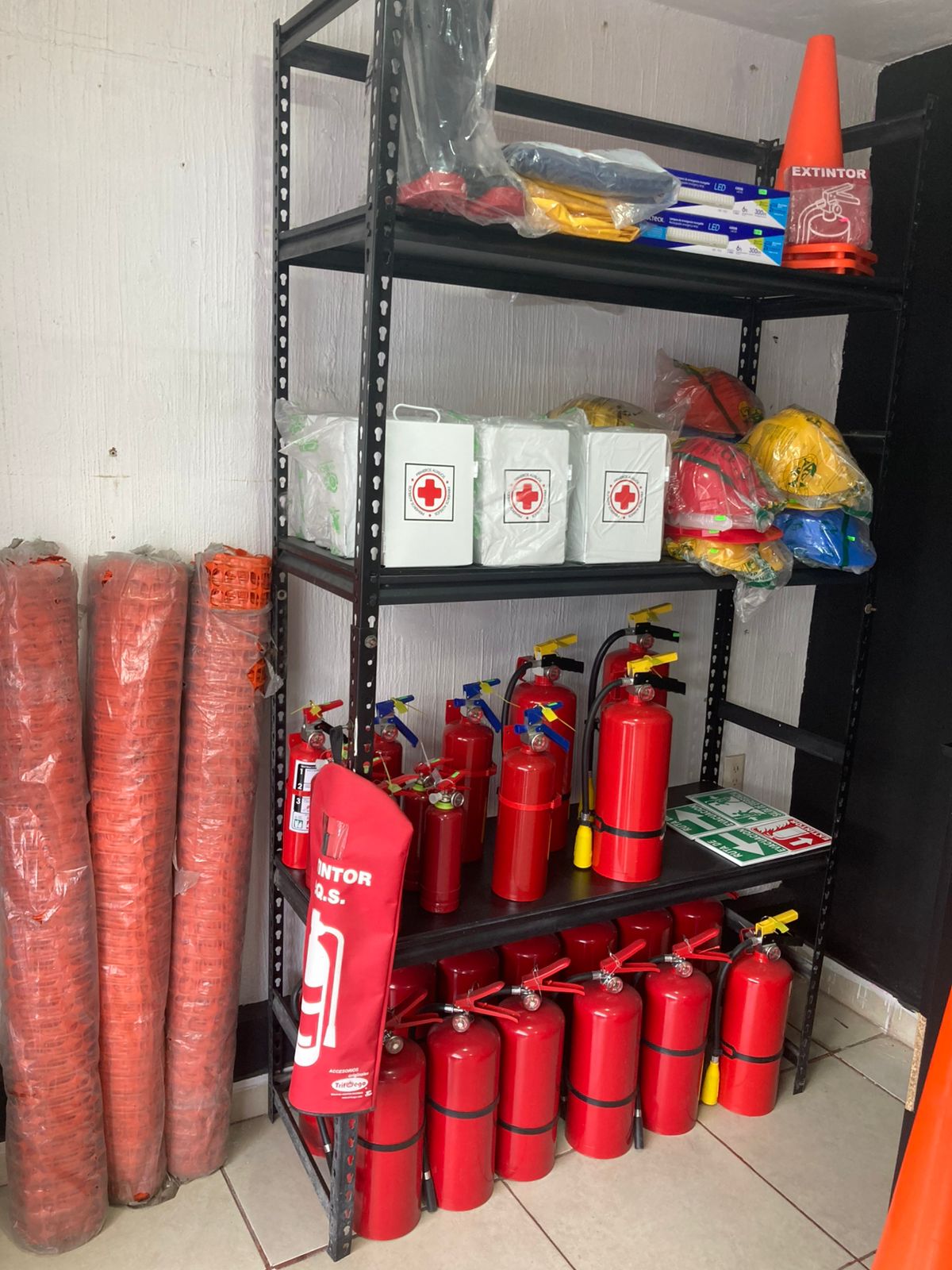 Estantes en bodega con múltiples extintores rojos listos
