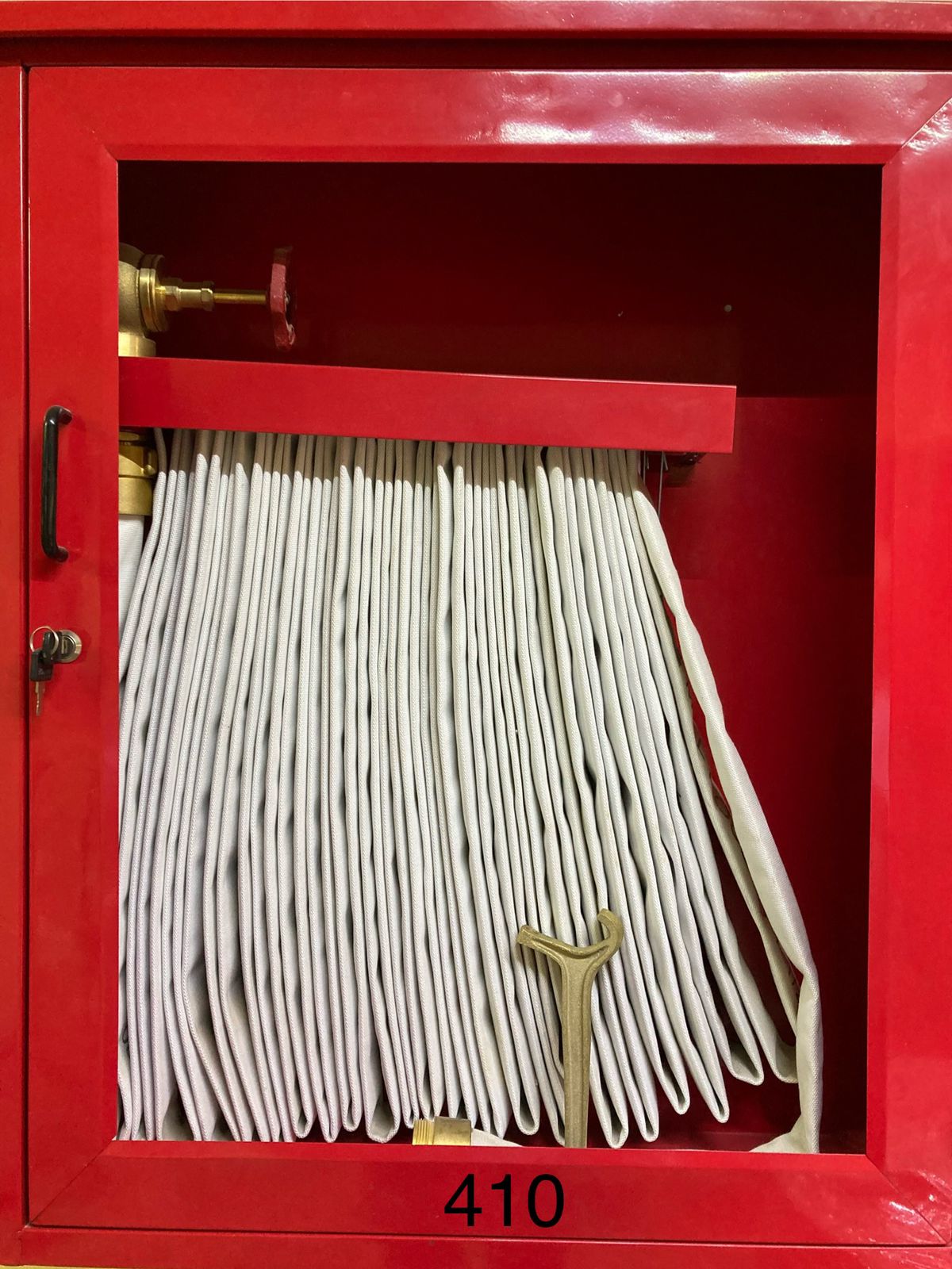 Gabinete rojo con manguera contra incendios enrollada